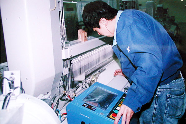 公司技工正在對布機(jī)進(jìn)行調(diào)試